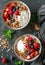 Two bowls of granola with fruits, Greek yogurt and berries top view