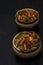 Two bowls of Italian pasta with bell papers on a black background