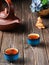 Two bowls with red tea, a clay teapot on the table, a tea ceremony. Freshly brewed black tea, steam rises above the cups, warm