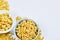 Two bowls of uncooked pastas on white background