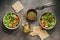 Two bowls of vegan and vegetarian dietary salad of fresh vegetables, chickpeas and seeds on a dark rustic background. View from
