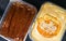 two box of cake with chocolate powder and caramel cream toppings on black background viewed from top