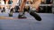 Two boxers fight in the boxing ring in boxing shoeses. Low section of male boxer standing against referee by athlete