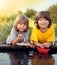 Two boys allowed paper boats from the pier of river