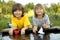 Two boys allowed paper boats from the pier of river