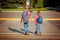 Two boys with backpack walking, holding on warm day on the road
