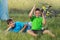 Two boys on a bike trip, resting sitting on the grass, tent and bike in the background