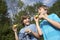Two Boys Blowing Soap Bubbles In Park