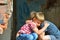 Two boys, brothers orphans were left without housing and sit near the ruins of the building in an embrace with each other and cry