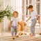 Two boys brothers plaing with wooden cube blocks on knitted carpet on the floor indoor. Knitted style in the interior: plaid and
