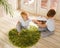 Two boys brothers plaing with wooden cube blocks on knitted grass carpet on the floor indoor. Knitted style in the interior: