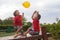 Two boys, brothers, playing with yellow balloon in the park