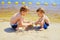 Two boys building sandcastle on the beach