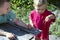 Two boys carefully examine the worm. A pretty baby holds a worm