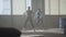 Two boys dancing in front of the large window in abandoned building. Teenagers making dance move simultaneously. Guys