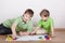 Two boys draw paints on sheets of paper