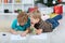 Two boys draw Santa Claus on the paper on the floor in the nursery.