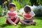 Two boys, eating watermelon in the garden