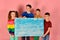 Two boys and a girl are holding a blank poster for inscription and text