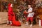 Two boys give each other gifts for Christmas. Santa costume