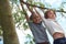 Two boys hanging from a tree