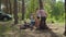 Two boys helping two moms to put up a tent in forest for their local family camping tourism. Family eco summer tourism