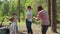 Two boys helping two moms to put up a tent in forest for their local family camping tourism. Family eco summer tourism