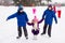 Two boys helps girl learn to skate