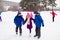 Two boys helps girl learn to skate