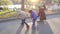 Two boys and his mother funny ride on rollers and skateboard