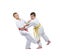 Two boys in judogi are training slicing down under leg