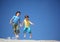 Two boys jump on sand