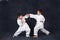 Two boys of the karate in a white kimono battle