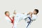 Two boys in karategi are beating blows kicks