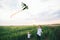 Two boys launching a kite on the wheat filed background. Brotherhood conception