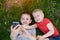 Two boys make selfie on a smartphone while lying on the grass. Top view