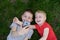 Two boys make selfie on a smartphone while lying on the grass. Top view