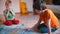 Two boys play a game on the floor at home.