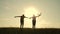 Two boys play with a wooden plane at sunset. Silhouette of children playing with an airplane. Dreams of flying. Children