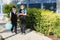 Two boys, schoolchildren in black school uniforms with backpacks in a medical mask go to school independently, hold hands,