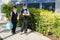 Two boys, schoolchildren in black school uniforms with backpacks in a medical mask go to school independently, hold hands,