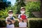 Two boys, schoolchildren in black school uniforms with backpacks in a medical mask go to school independently, hold hands,