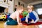 Two boys sitting on the floor playing on tablet.