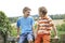 Two Boys Sitting On Gate Chatting Together