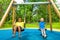 Two boys swing together and hold chains of swings