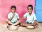 Two Boys teenagers pupils being served Meal plate of rice In government School Canteen. Unhealthy food for poor children