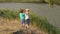 Two boys throw stones into the lake in summer day.