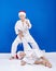 Two boys are trained judo throws in Santa Claus caps