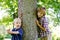 Two boys beside tree