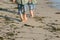 Two boys walk on the beach barefoot doing grounding